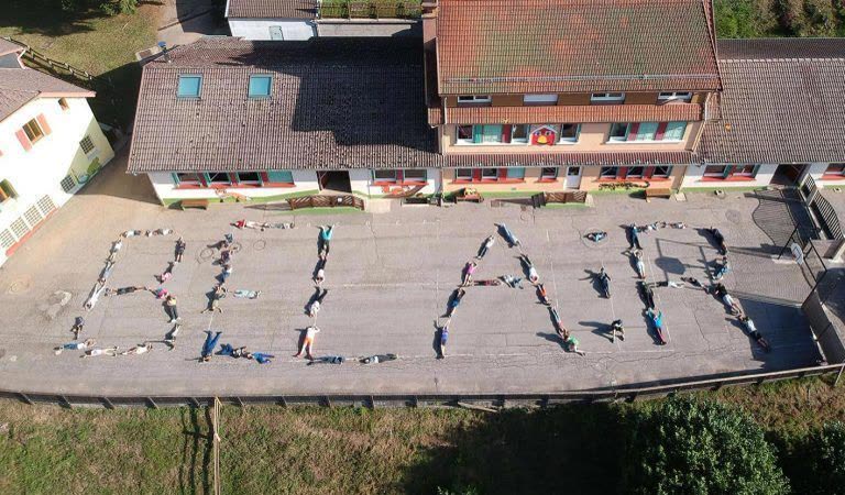 Vue aérienne d'enfants formant les lettres « Bel Air » devant un bâtiment