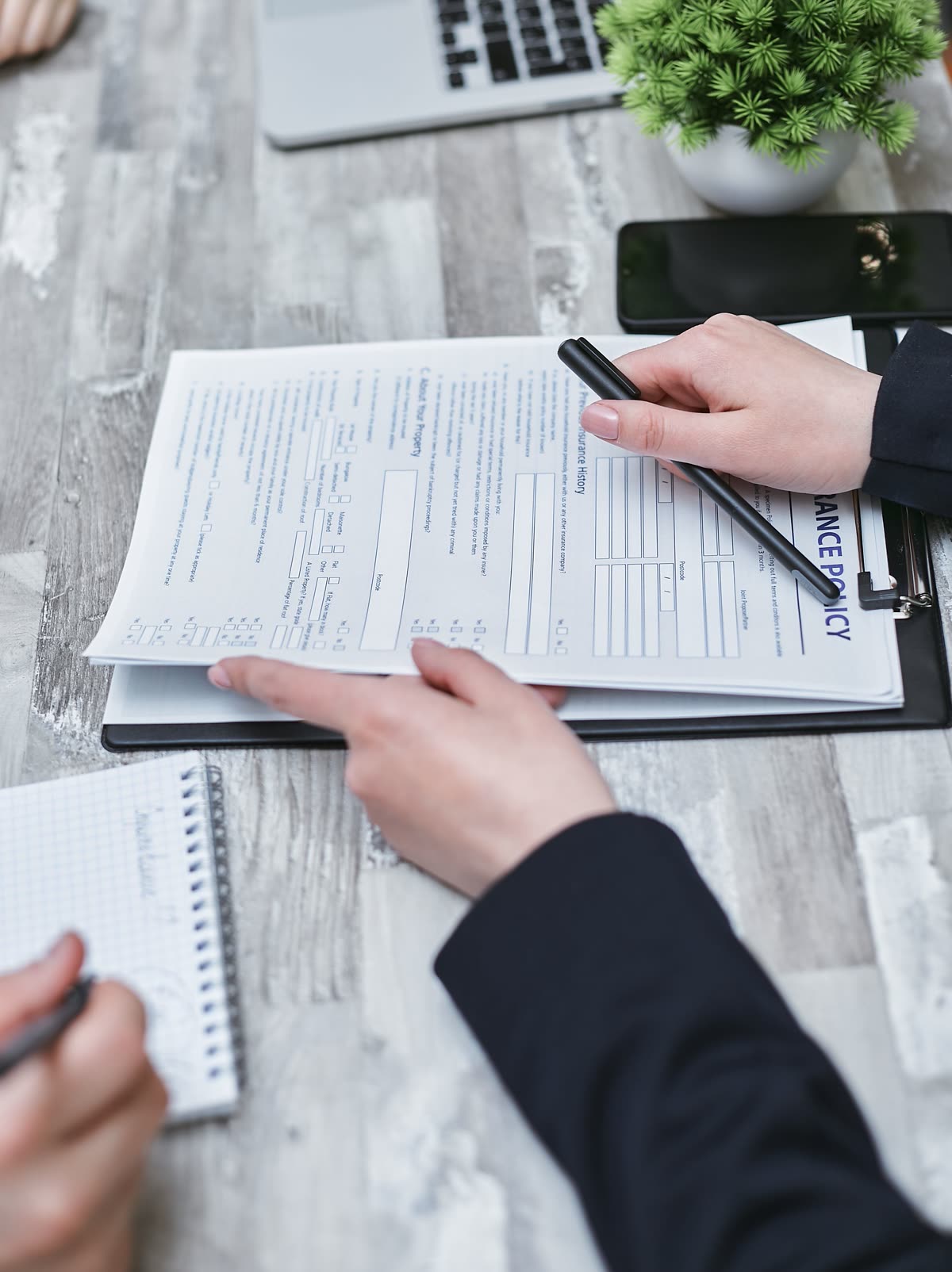 Deux personnes remplissent ensemble un formulaire de demande, stylo à la main