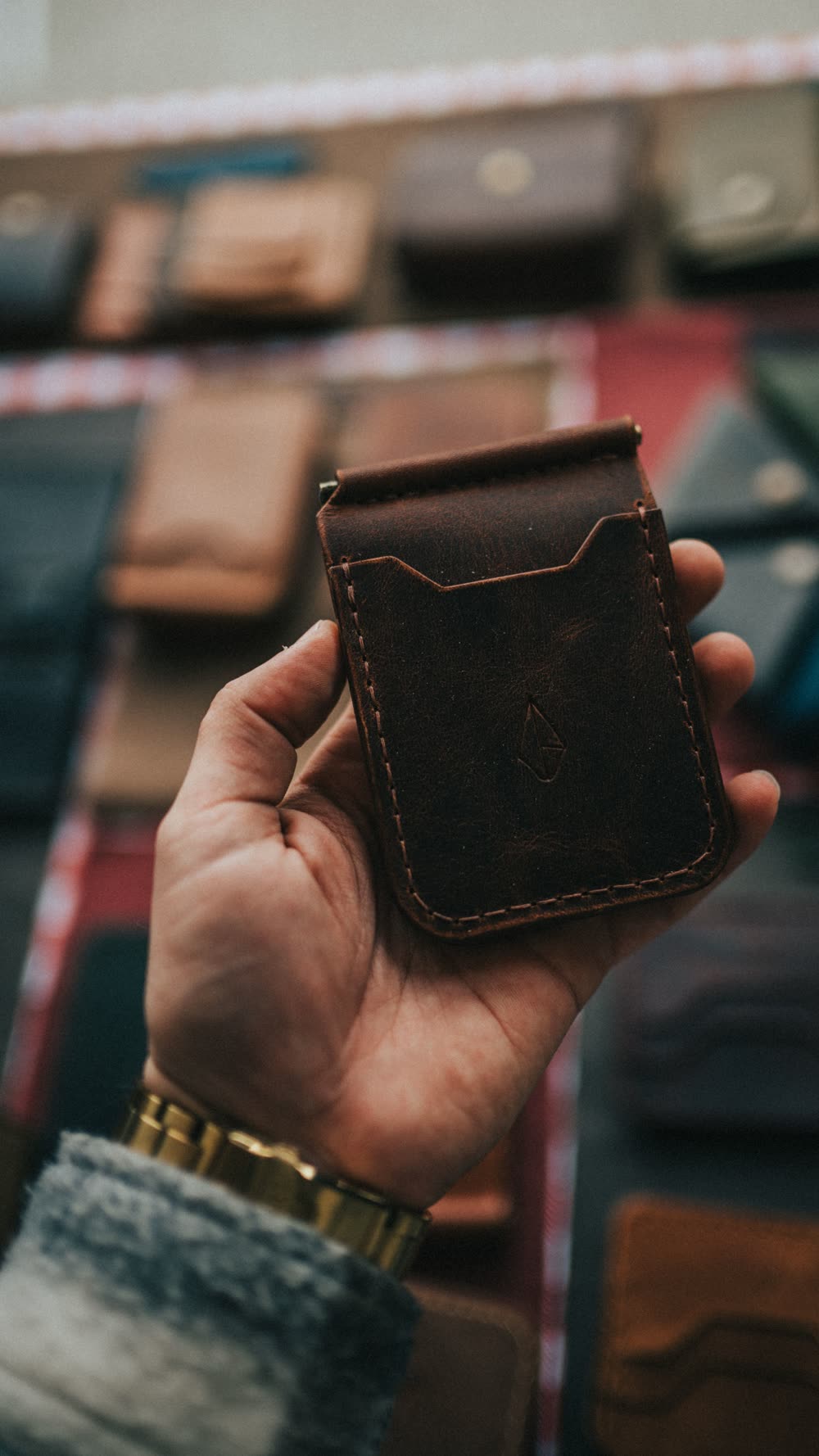 Une main tient un porte-cartes en cuir ouvert