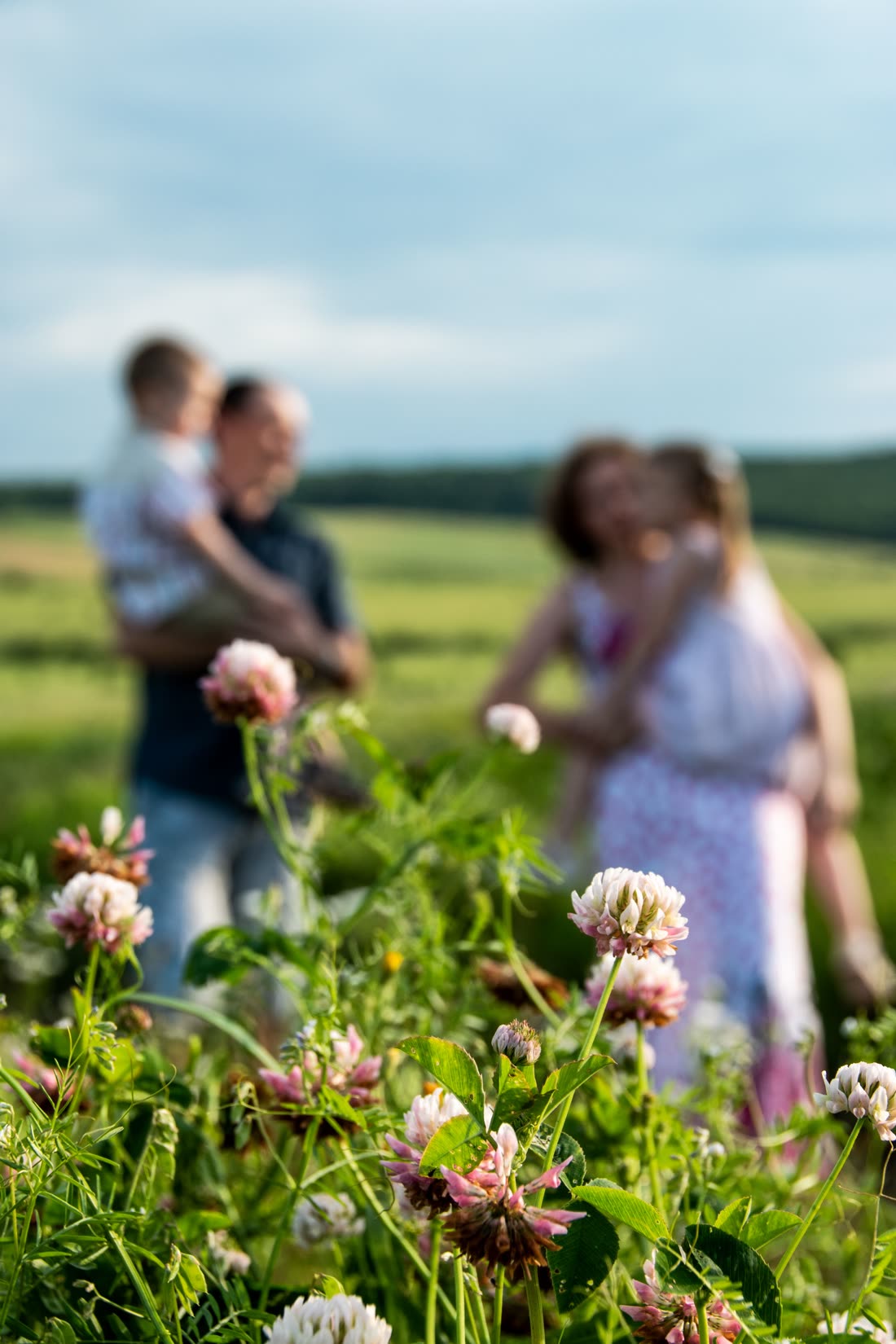 Une famille marche dans un pré en fleurs, au printemps