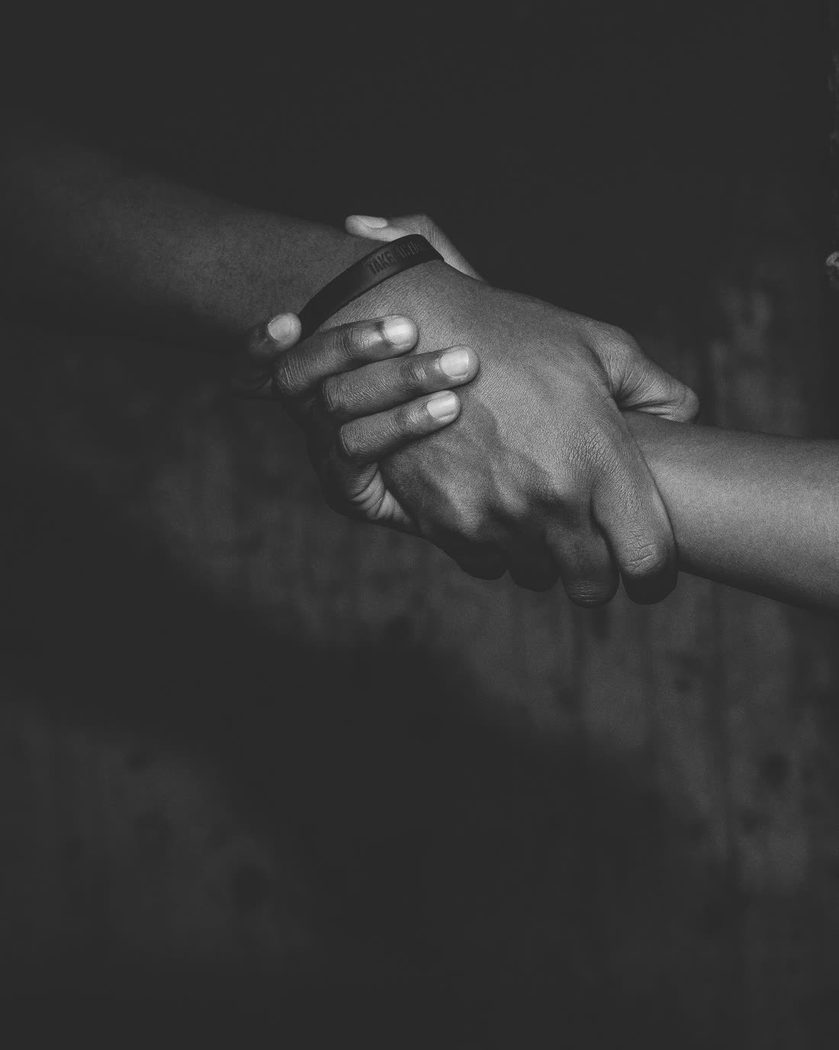 Deux mains se saisissant l'une l'autre, photographie en noir et blanc