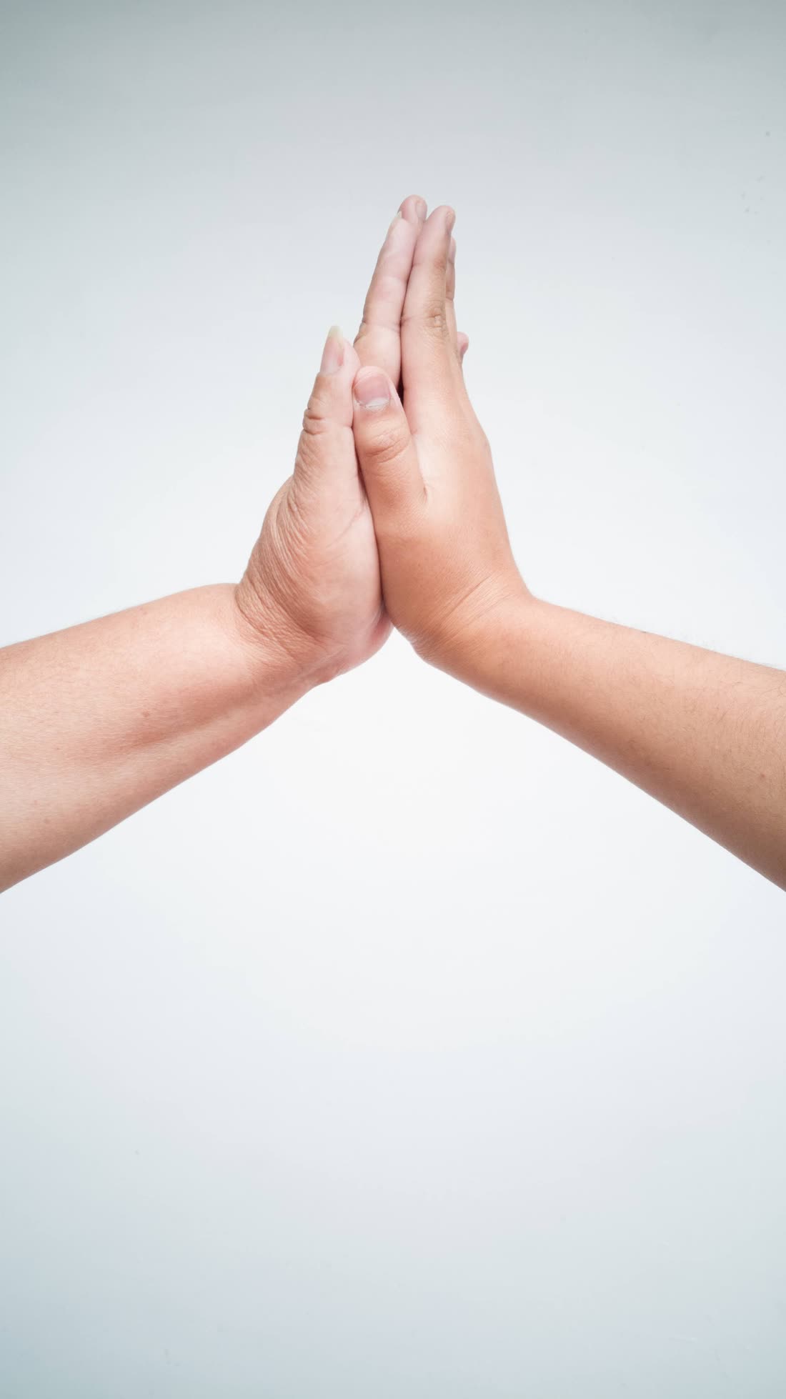 Deux mains se rejoignent paume contre paume sur fond clair