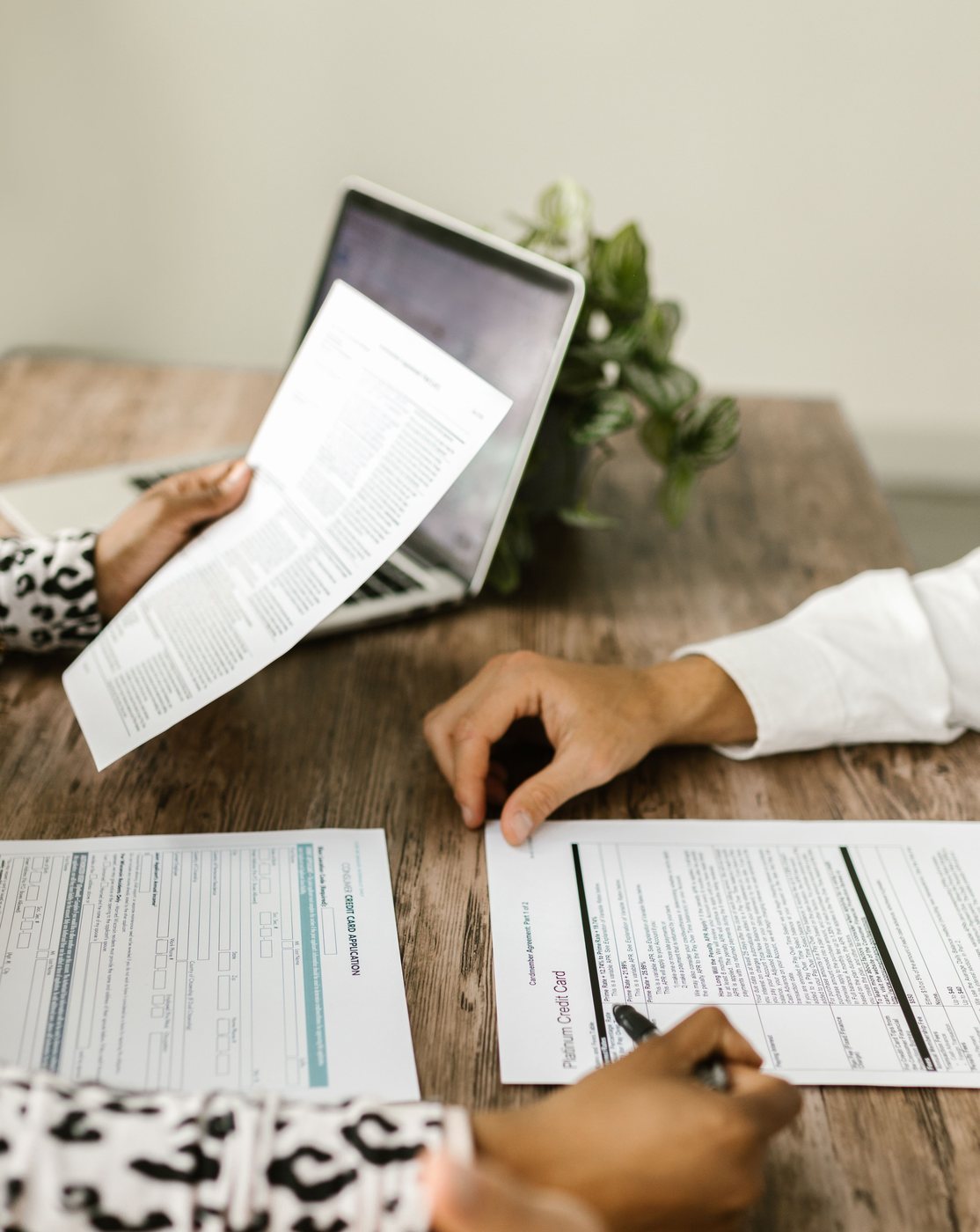 Deux personnes comparent des documents contractuels autour d'une table