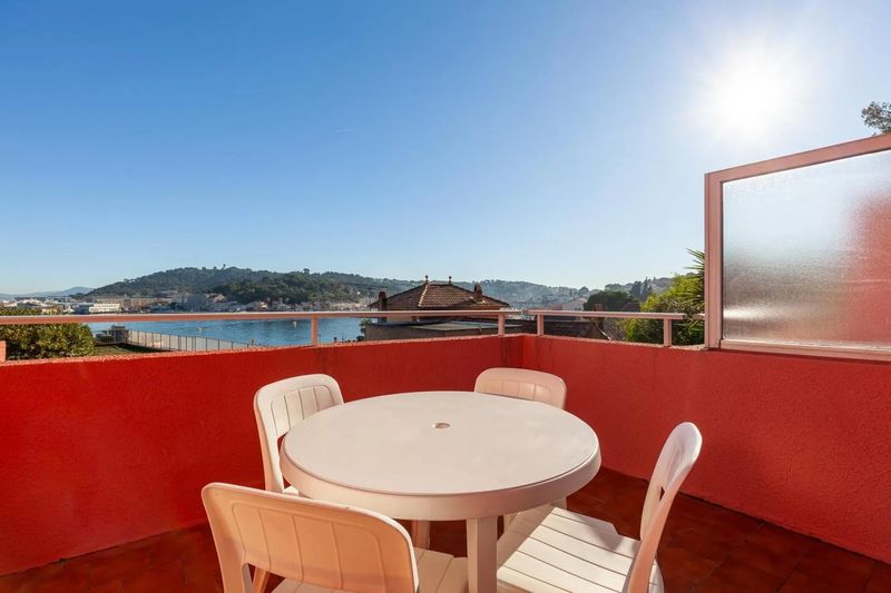 Une terrasse avec table et chaises, vue sur la mer